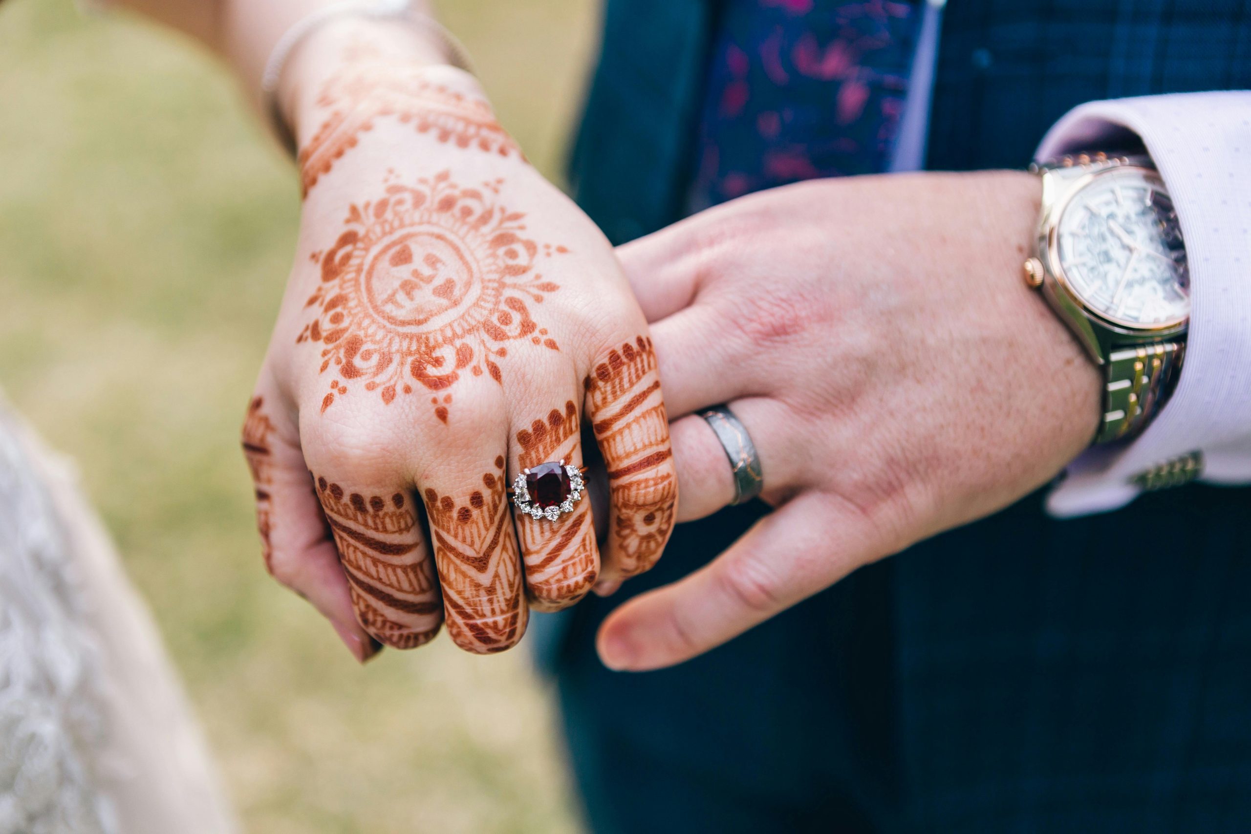 Close-up of hands with henna tattoos and rings at an outdoor ceremony in North Ryde, NSW.